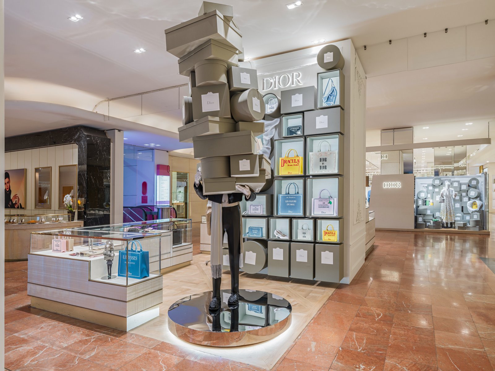 In-store display with a box-covered mannequin figure atop stacked grey boxes.