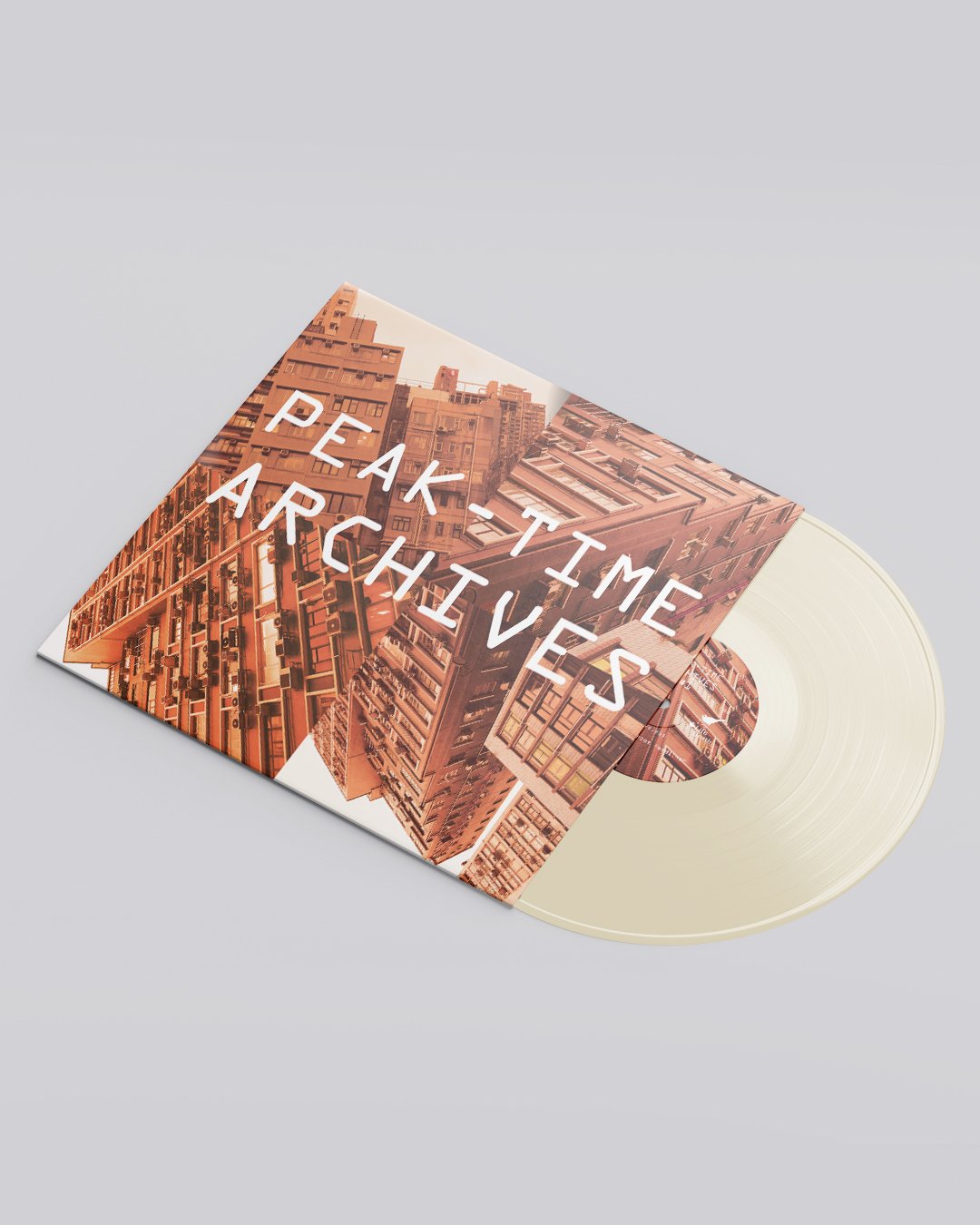 Angled perspective mockup of the Peak-Time Archives #1 12-inch vinyl lying flat, the orange tower-block sleeve with a cream-clear record sliding out.