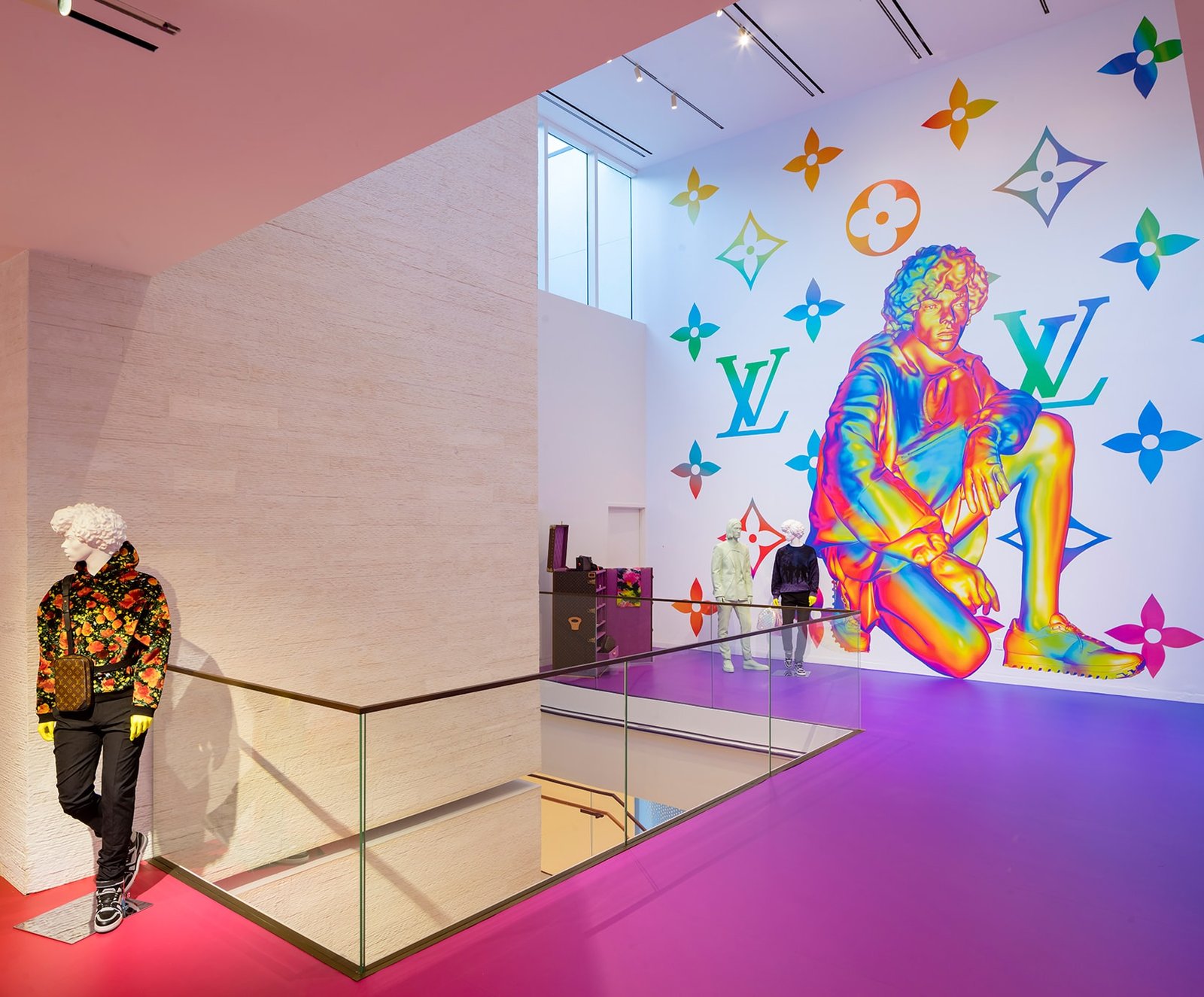 Interior stair landing with a large iridescent rainbow figure mural and pink and purple floors.